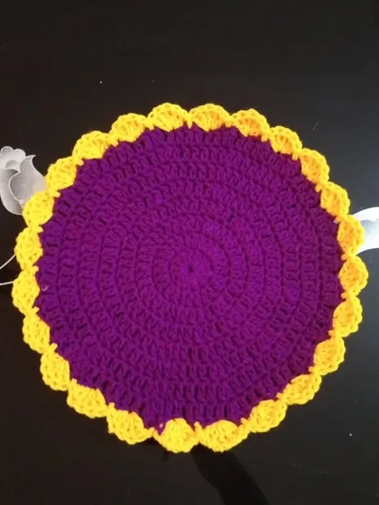 A round table mat in purple and yellow.