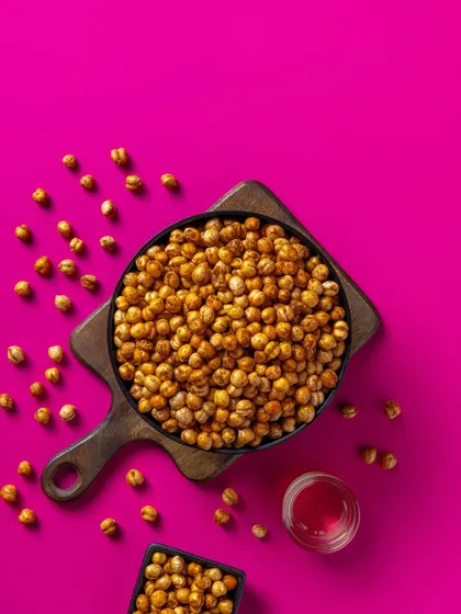 Roasted chickpeas shot against a bright pink background. This bold and modern approach is effective for creating memorable e-commerce and packaging visuals.