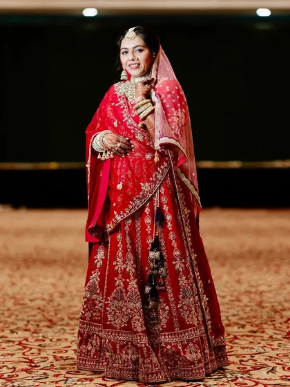 A full view of this bride's magnificent red lehenga. The soft glam makeup ensures her face remains the focal point.