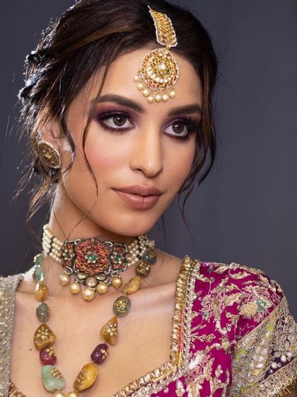 A close-up of a regal look with a dramatic purple smokey eye. This is a great option for a bride who wants a bold reception look.