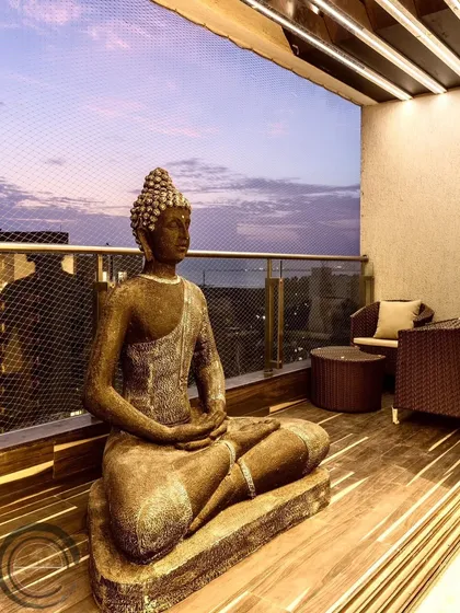 What could be better than a gorgeous balcony with a beautiful Buddha statue? This space is designed for calm reflection, with a comfortable seating area and a view of the evening sky.