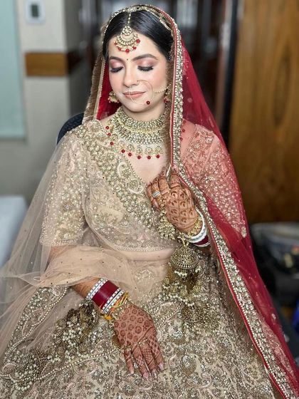 A full shot of bride Nupur, seated and looking serene in her complete bridal ensemble.