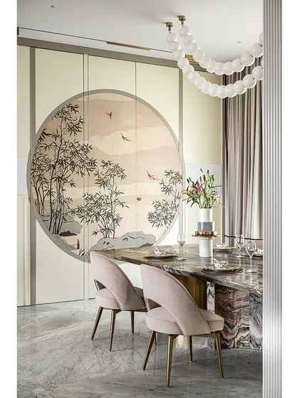 This dining area features a stunning veneer marquetry artwork on pocket shutters, which conceal a spacious crockery unit. The custom marble dining table and soft pink chairs create an elegant setting, while the bubble chandelier adds a touch of modern whimsy.
