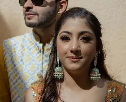 A candid portrait of a couple from their engagement or pre-wedding event. The warm sunlight and their happy expressions capture a moment of love and connection.