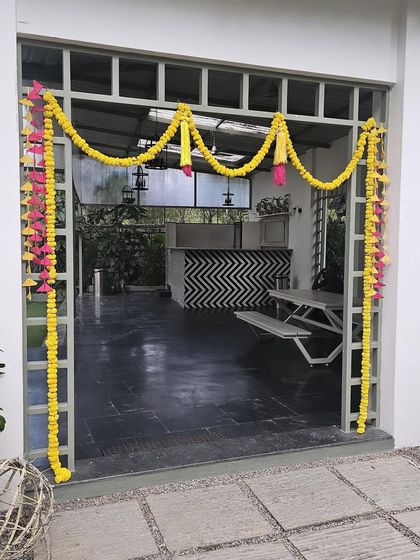 A simple yet elegant entrance decoration for a traditional function. I used marigold flower garlands with decorative hangings to frame the doorway.