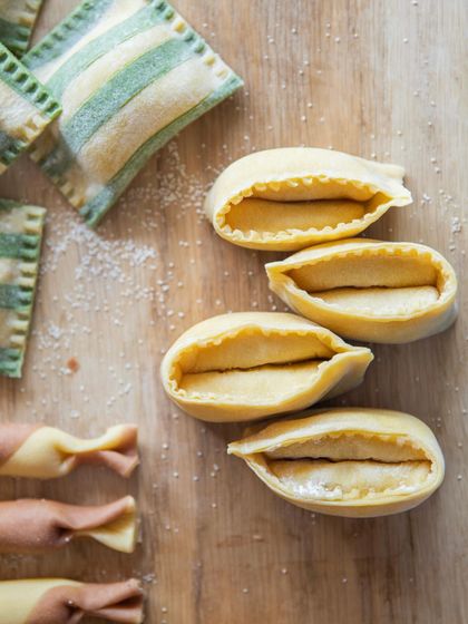The art of fresh pasta. Here you can see the delicate shapes of our doppio agnolotti and striped ravioli, all made by hand in our kitchen daily. This is the foundation of many of our signature dishes.