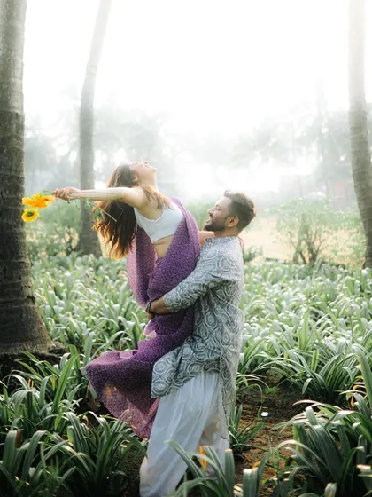 A joyful lift amidst a field of green, with sunlight filtering through the trees. This shot is full of energy and romance, perfect for a save the date announcement.