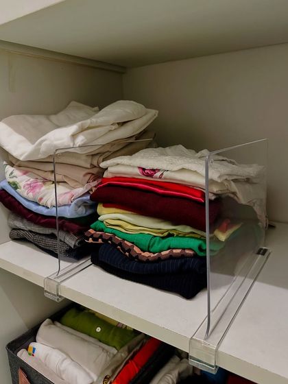 Shelf dividers are a simple but powerful tool. They prevent tall stacks of clothes from toppling over, keeping shelves neat and making it easy to grab what you need without disturbing the rest.