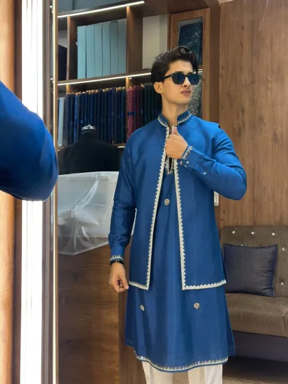 A perfect look for a wedding guest. This custom-stitched royal blue kurta is paired with an open jacket featuring delicate white border embroidery. It’s a modern, elegant, and comfortable choice that ensures you stand out with class at any celebration.