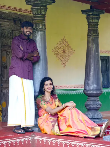 Posing on the porch of a traditional home, this couple's ethnic attire perfectly matches the authentic, cultural setting of the photoshoot.