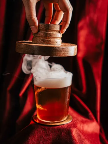 A cocktail should be an experience. We used dramatic lighting and a billow of smoke to create a moody, theatrical shot for this smoked cocktail at Amelia, turning a simple drink into a captivating visual story.