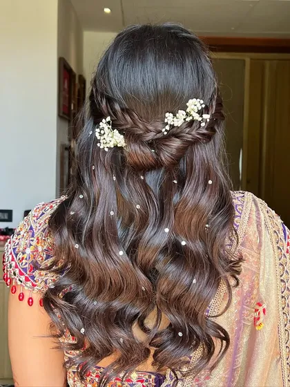 A full back view of the Haldi hairstyle, showing the beautiful flow of the waves and the delicate braided detail.