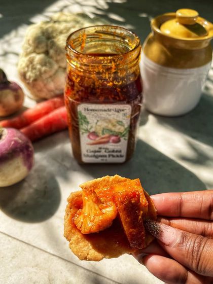 A spoonful of our Gajar Gobhi Shalgam pickle on a crispy mathri. This is how we love to enjoy the sweet, spicy, and tangy flavours of our special winter pickle.