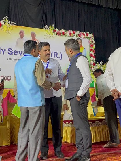 Shaking hands with a fellow organizer on stage, a gesture of thanks for their hard work and collaboration.