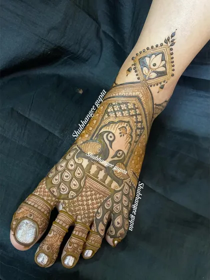 This design for the foot features a beautiful peacock as the central element. The feathers of the peacock flow down towards the toes, creating a graceful and artistic look.