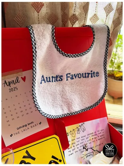 A custom 'Aunt's Favourite' bib, perfect for a baby shower gift from a loving aunt. The calendar marks the baby's due date.
