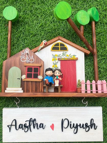 This design is a true heart-stealer. It features a Ganesha motif for blessings, a miniature couple, and colorful hand-painted details on a solid wood base. The combination of natural wood and bright colors creates a warm and inviting custom family name sign.