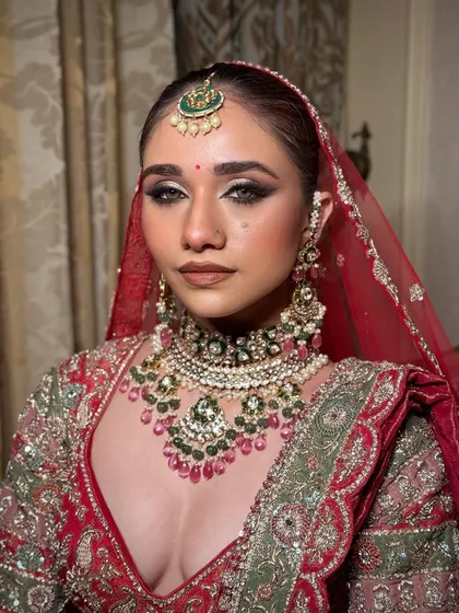 Here you can see the power of a perfectly defined eye and a flawless base. The red dupatta frames the face, making the makeup pop and creating that iconic bridal portrait.