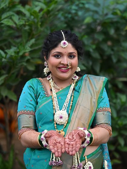 A joyful portrait of the mom-to-be. Her hands are filled with 'oti', a traditional offering, and her face is lit up with a beautiful smile.