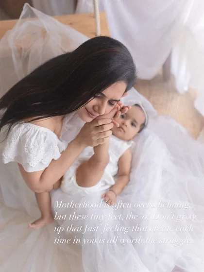 Motherhood is a dance. This image captures the joy of helping a baby take her first wobbly steps, a precious milestone filled with laughter and encouragement.