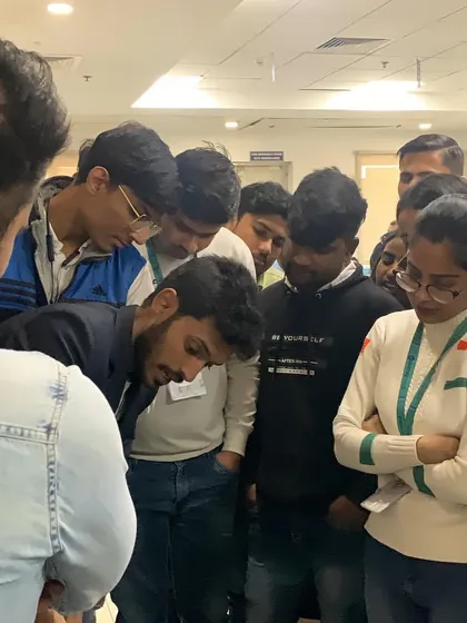 The intense curiosity of the audience as they gather closely to witness a card trick. This type of engagement is what makes close-up magic so powerful for team bonding.