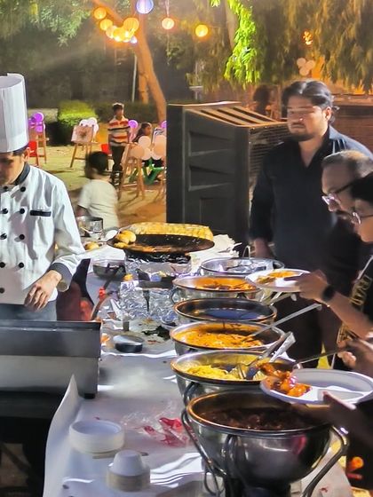 Our chefs serving a variety of dishes at an outdoor buffet. We manage the entire food service, ensuring the buffet is always well-stocked and presentable.