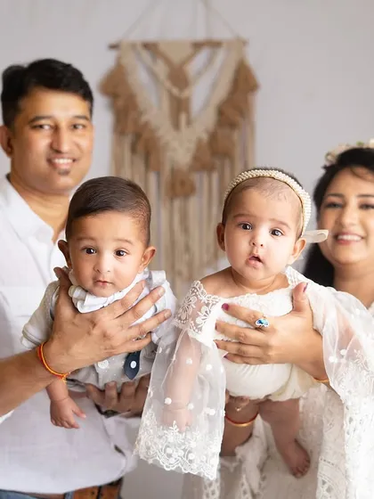 A classic family portrait with the proud parents holding their twin babies. Capturing a family of four is a beautiful milestone.