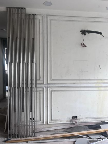 A look at the living room during the work-in-progress stage. The wainscoting panels are up, and a metal partition screen is waiting to be installed. This is where the vision starts taking physical shape.