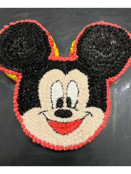 A close-up of the Mickey Mouse cake, highlighting the star-tip piping technique used to create the texture.