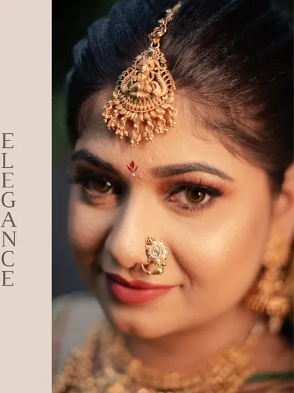 An artistic close-up focusing on the bride's "Elegance." This shot highlights her beautiful eyes, the intricate design of her maang tikka, and her traditional nose ring.