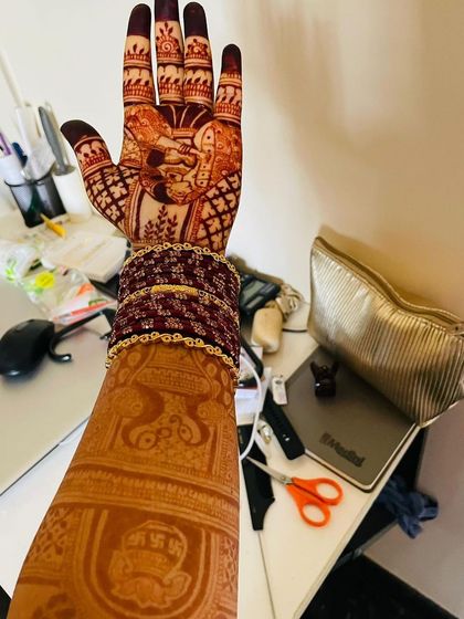 Another view of the long-lasting henna stain, showcasing the detailed portrait work on the palm.