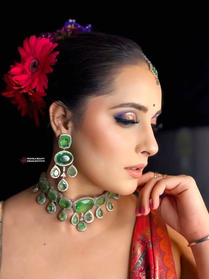 A side profile that showcases the sleekness of the updo and the pop of color from the flowers. This hairstyle is perfect for highlighting a sharp jawline and statement earrings.