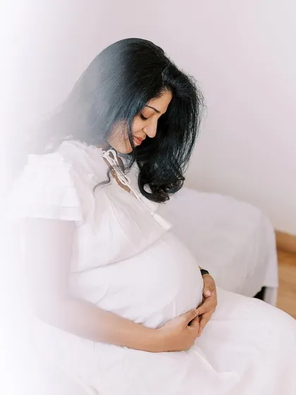 A soft and dreamy portrait of an expecting mother. The bright, high-key lighting creates an ethereal feel, emphasizing the beauty and tranquility of this special time.