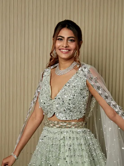 A full-length view of this breathtaking silver lehenga. The makeup and hair were designed to complement the outfit and create a head-to-toe glamorous look.