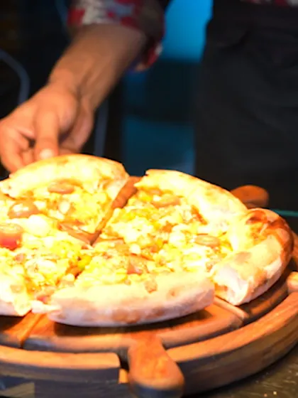 A close-up of a wood-fired pizza, sliced and ready to be enjoyed. A rustic Italian classic, served with gourmet flair.