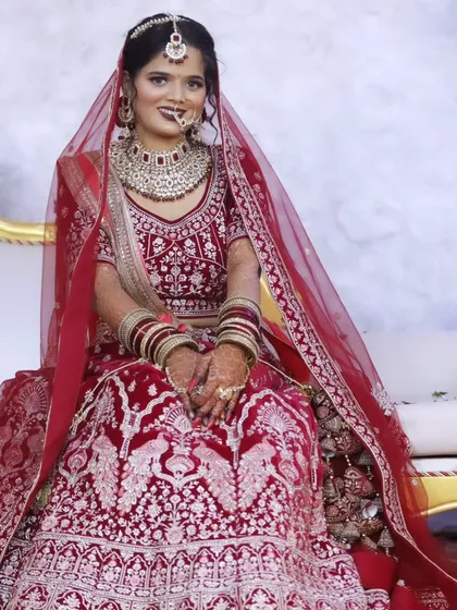 A full-length view of the bride in her magnificent red lehenga, showcasing the complete look with perfectly draped dupatta and heavy jewelry.