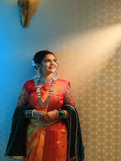 A full-length portrait showcasing the beautiful drape of her saree and the complete bridal look. The makeup and hair are styled to create a cohesive and elegant appearance.