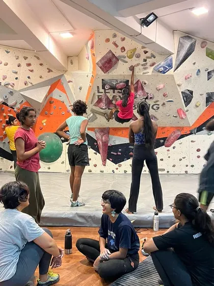 Climbers watching and learning from each other during a session. The gym is a space for both individual effort and shared experience.