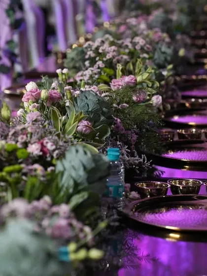 The smallest details make the biggest impact. This close-up of a tablescape shows our focus on precision, from the polished brass thalis to the delicate floral centerpieces, all brought together by coordinated ambient lighting.