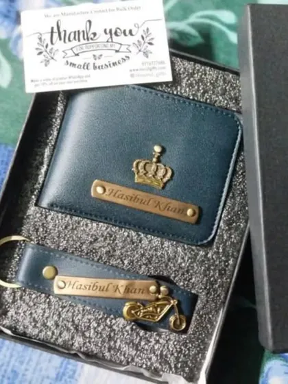 A customer's order of a personalized wallet and keychain set in navy blue, featuring a crown charm on the wallet and a bike charm on the keychain.