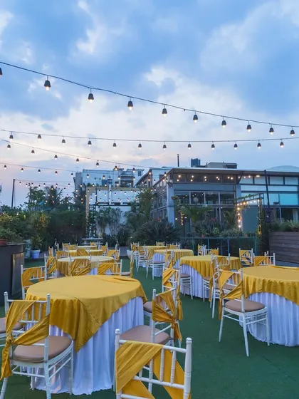A beautiful daytime shot of the Terrace Garden dining setup, with the city skyline in the background.