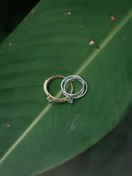 A minimalist and artistic shot of the engagement rings resting on a large green leaf, using nature as a beautiful backdrop to symbolize a new beginning.