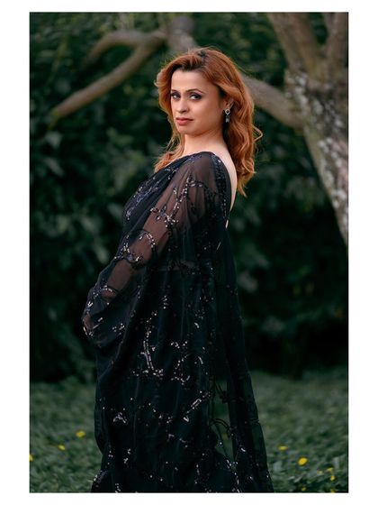 An elegant outdoor portrait of a woman in a classic black sequined saree. This demonstrates my ability to shoot modern, sophisticated looks.