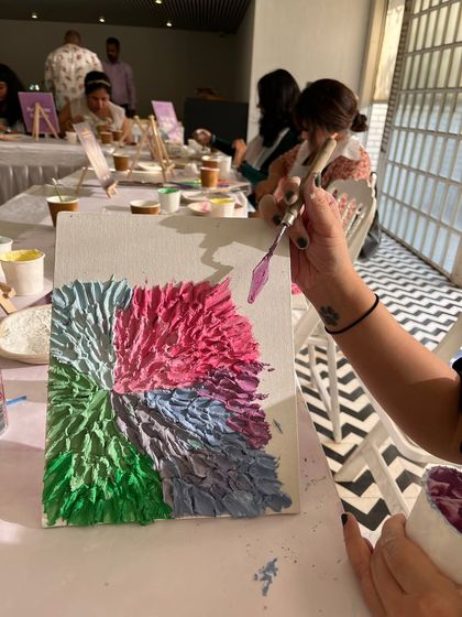 Using a palette knife to create petals with thick texture paste. This is the most satisfying part of the process for many people.