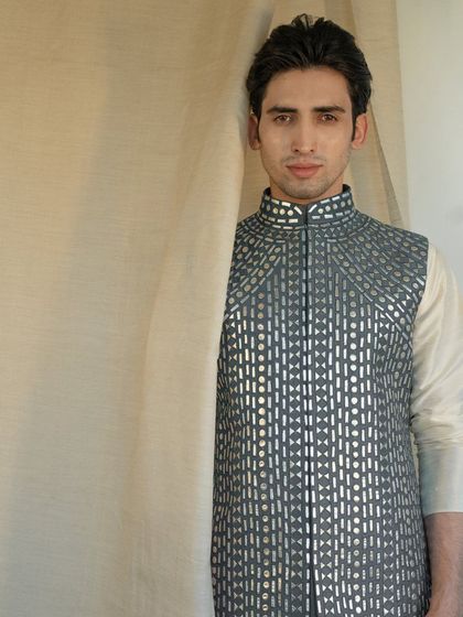 Blending tradition with contemporary flair, this exquisite grey jacket with geometric mirror work creates a captivating ensemble.