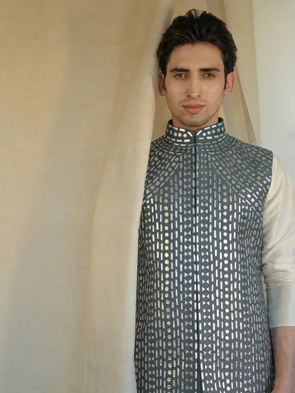 Blending tradition with contemporary flair, this exquisite grey jacket with geometric mirror work creates a captivating ensemble.