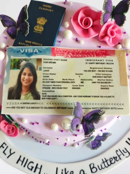 A "Fly High" cake celebrating a US visa approval. The cake features an edible print of the visa and passport, decorated with butterflies to symbolize a new journey.