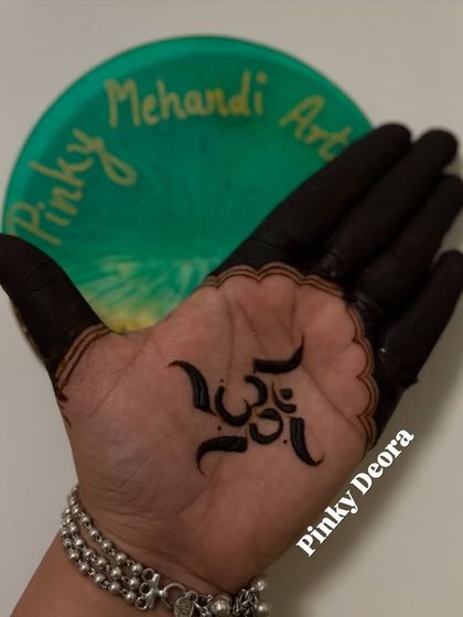 Another angle of the "Om" mehndi design, showcasing its clean lines and the rich color of the henna paste.