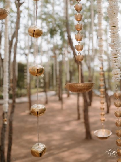 Hanging brass bells and floral details add a delicate, artisanal touch to the decor, creating a gentle soundscape as the breeze passes through.