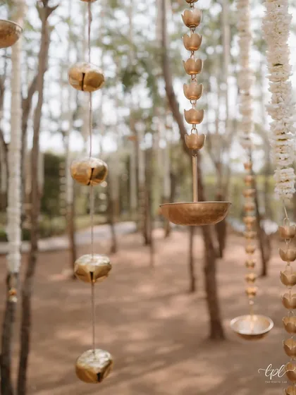 Hanging brass bells and floral details add a delicate, artisanal touch to the decor, creating a gentle soundscape as the breeze passes through.